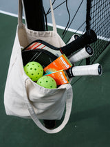 Tote bag with Sunii Energy Gum, pickleball raquets, pickleball balls,and sports gear, emphasizing portability and active lifestyle