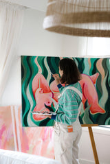 Woman painting indoors with Sunii Energy Gum nearby, showing creativity fueled by Sunii